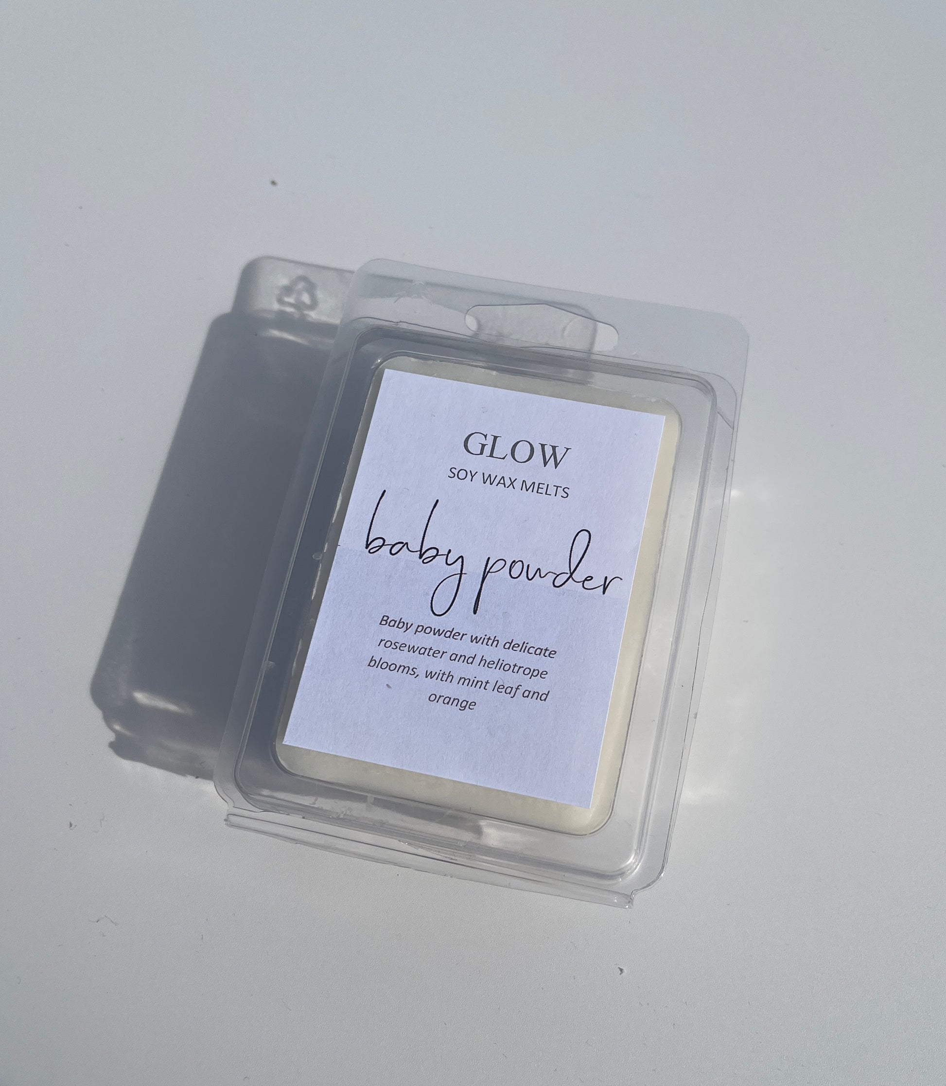 <img src="Baby_Powder_Clamshell" alt="Package of GLOW soy wax melts labeled 'Baby Powder' with six rectangular melts.">