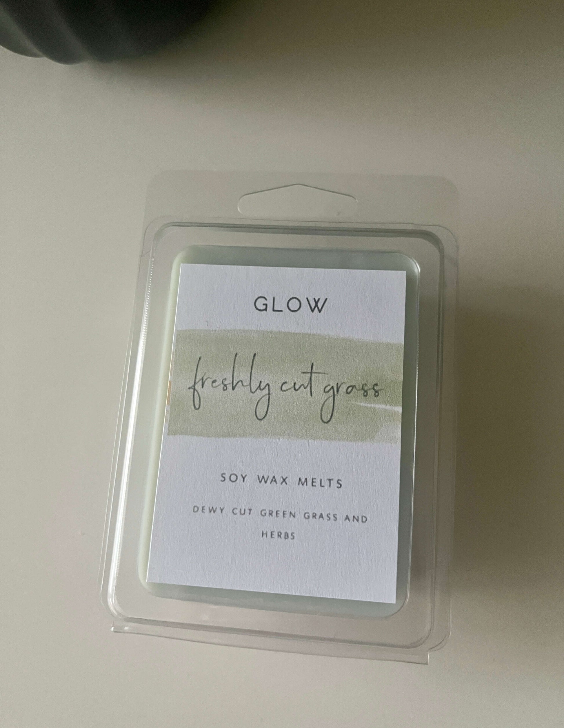 A glow clamshell package labelled Freshly Cut Grass with 6 green wax cubes 